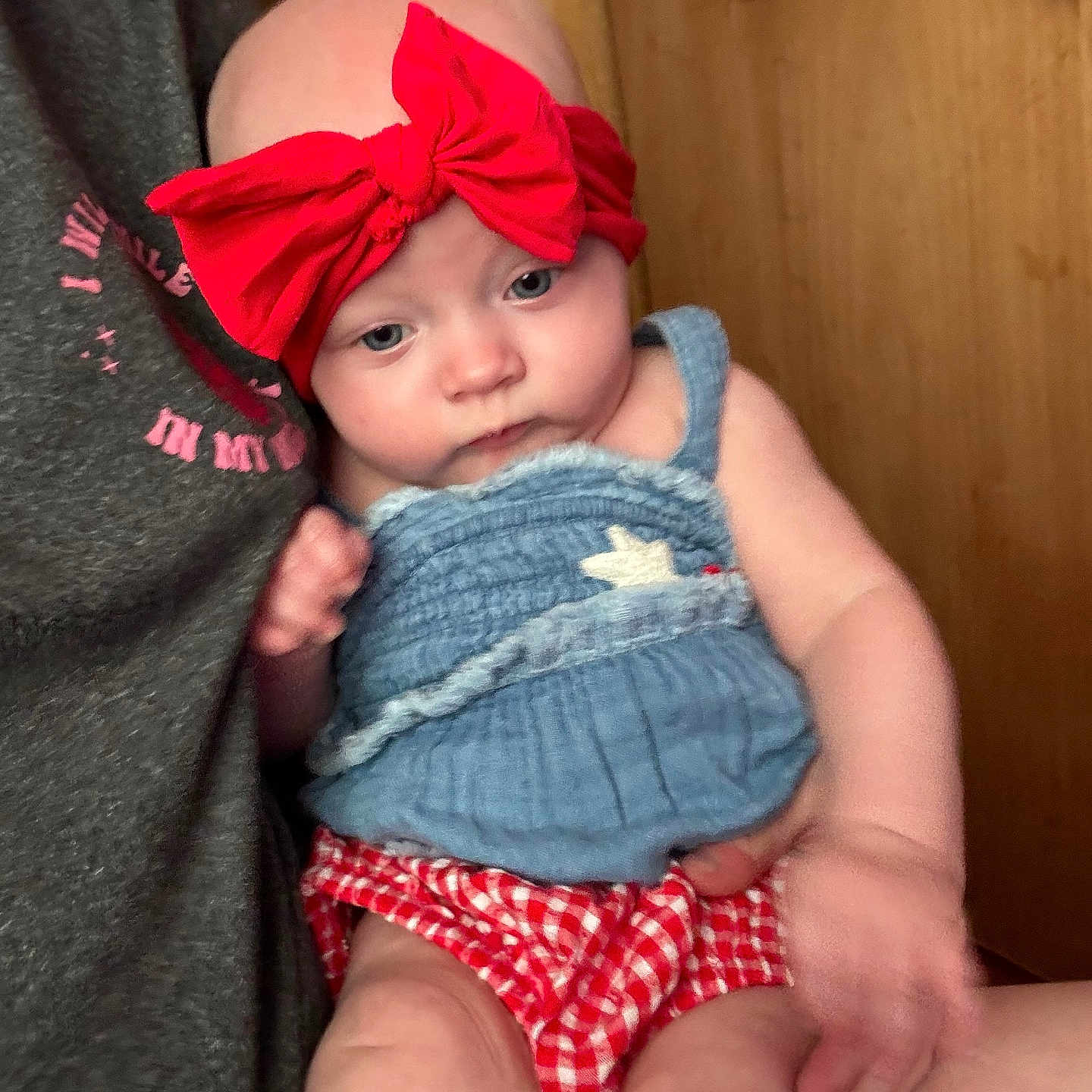 Amora joined the competition — help win amazing prizes! arm, baby, blue_top, casual, child, close_up, clothing, cute, door, face, hand, head, holding, indoor, infant, person, red_bow, red_checkered_bottoms, seated, skin