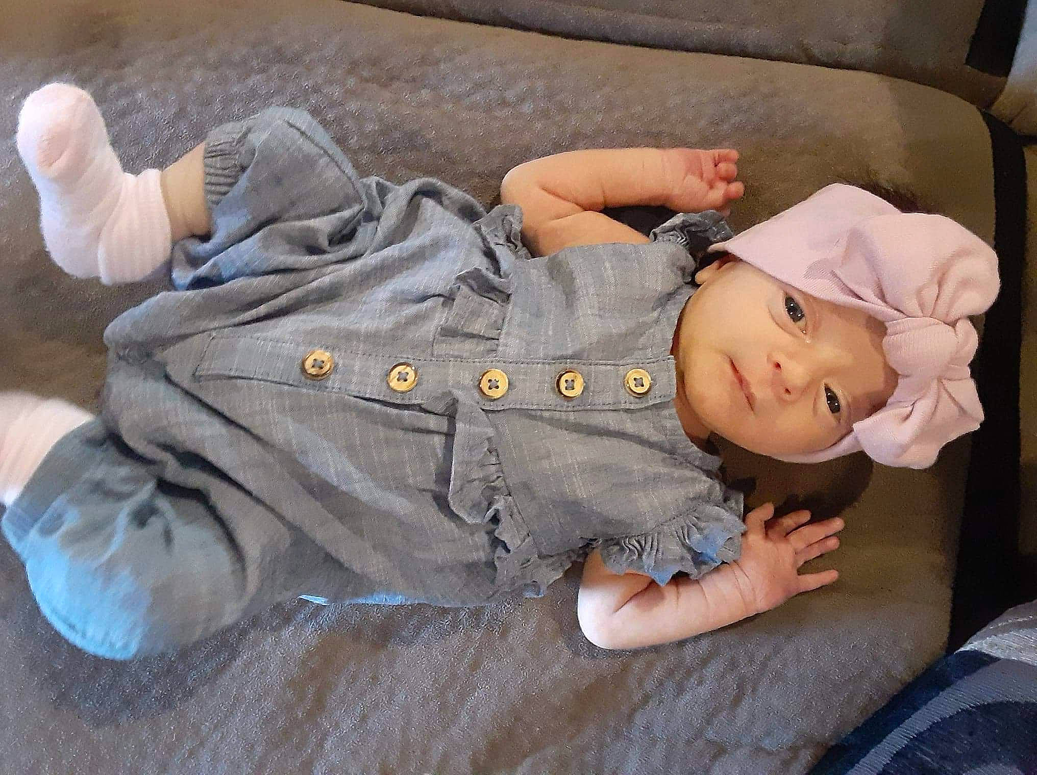 Emmarie is registered to the contest to win money with this photo: baby, baby_toddler_clothing, child, comfort, denim, finger, glasses, grass, hand, hat, headwear, human_body, joint, leg, person, sitting, skin, sleeve, thigh, thumb