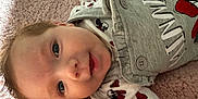 Lorelai is registered to the contest to win money with this photo: applique, baby, bed, bedroom, blanket, bodypart, bonnet, cap, clothing, coat, couch, crib, cushion, face, finger, fleece, furniture, glove, hand, happy