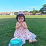 child, toddler, birthday, birthday_cake, happy_birthday, party_hat, crown, girl, curly_hair, smiling, pink_dress, sandals, sitting, grass, park, outdoor, sunny, portrait, dessert, celebration