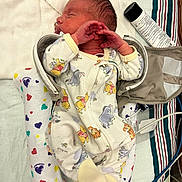 Jaxon joined the competition — help win amazing prizes! newborn, baby, infant, sleeping, portrait, onesie, clothing, hands, face, hair, hospital, changing_bag, medical_supplies, blanket, hearts, patterned, striped_fabric, lying_down, indoors, photography