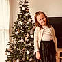 Lou-Ann participe au concours pour gagner de l'argent avec cette photo : child, girl, christmas_tree, ornaments, holiday, decorations, present, baubles, pine_tree, smile, portrait, home_interior, living_room, skirt, cardigan, television, floor, toy_polar_bear, festive, curtain