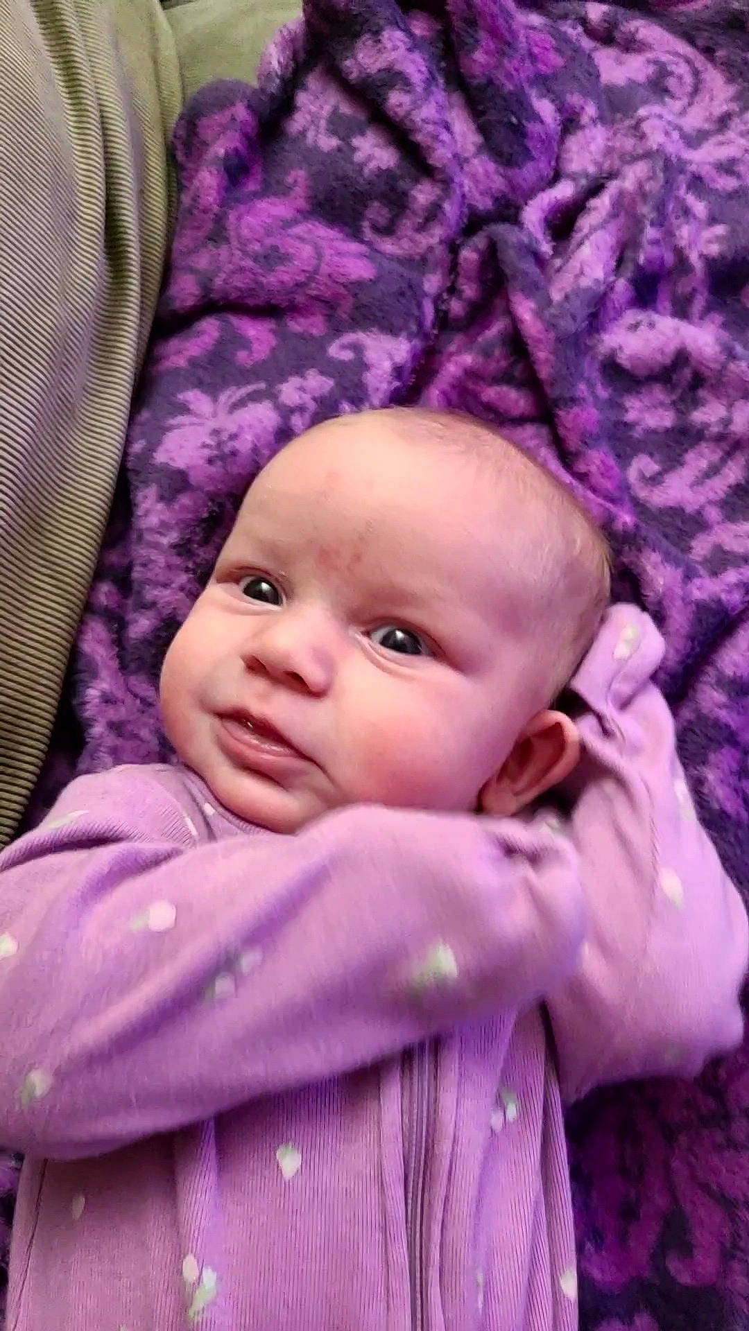 Emery is registered to the contest to win money with this photo: baby, baby_toddler_clothing, cheek, child, chin, comfort, eye, eyebrow, happy, iris, linens, magenta, pattern, person, pink, purple, skin, sleeve, textile, toddler