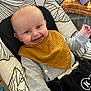 Ezio participe au concours pour gagner de l'argent avec cette photo : baby, smiling, bib, blue_eyes, infant, baby_seat, patterned_cushion, clothing, happy, face, child, sitting, indoor, cute, young_child, person, mouth_open, joyful, head, soft_fabric