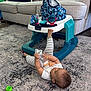 Jonathan is registered to the contest to win money with this photo: baby, baby_walker, carpet, child, couch, floor, foot, furniture, hand, head, indoor, living_room, person, pillow, play, soft_toy, striped_clothing, toy, walker, young_child