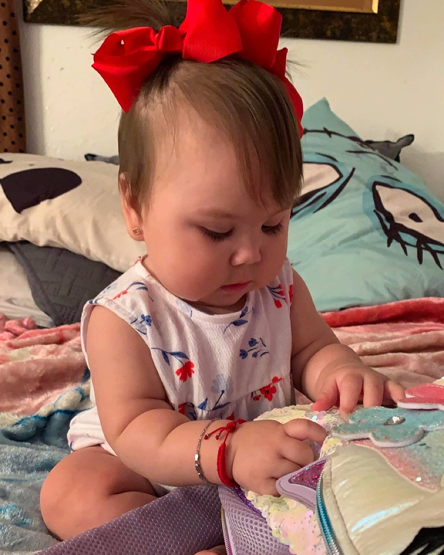 Kailani is registered to the contest to win money with this photo: baby, baby_toddler_clothing, carmine, child, costume_hat, fashion_accessory, fun, happy, headband, headpiece, linens, mammal, pattern, person, pink, room, sitting, skin, t_shirt, toddler