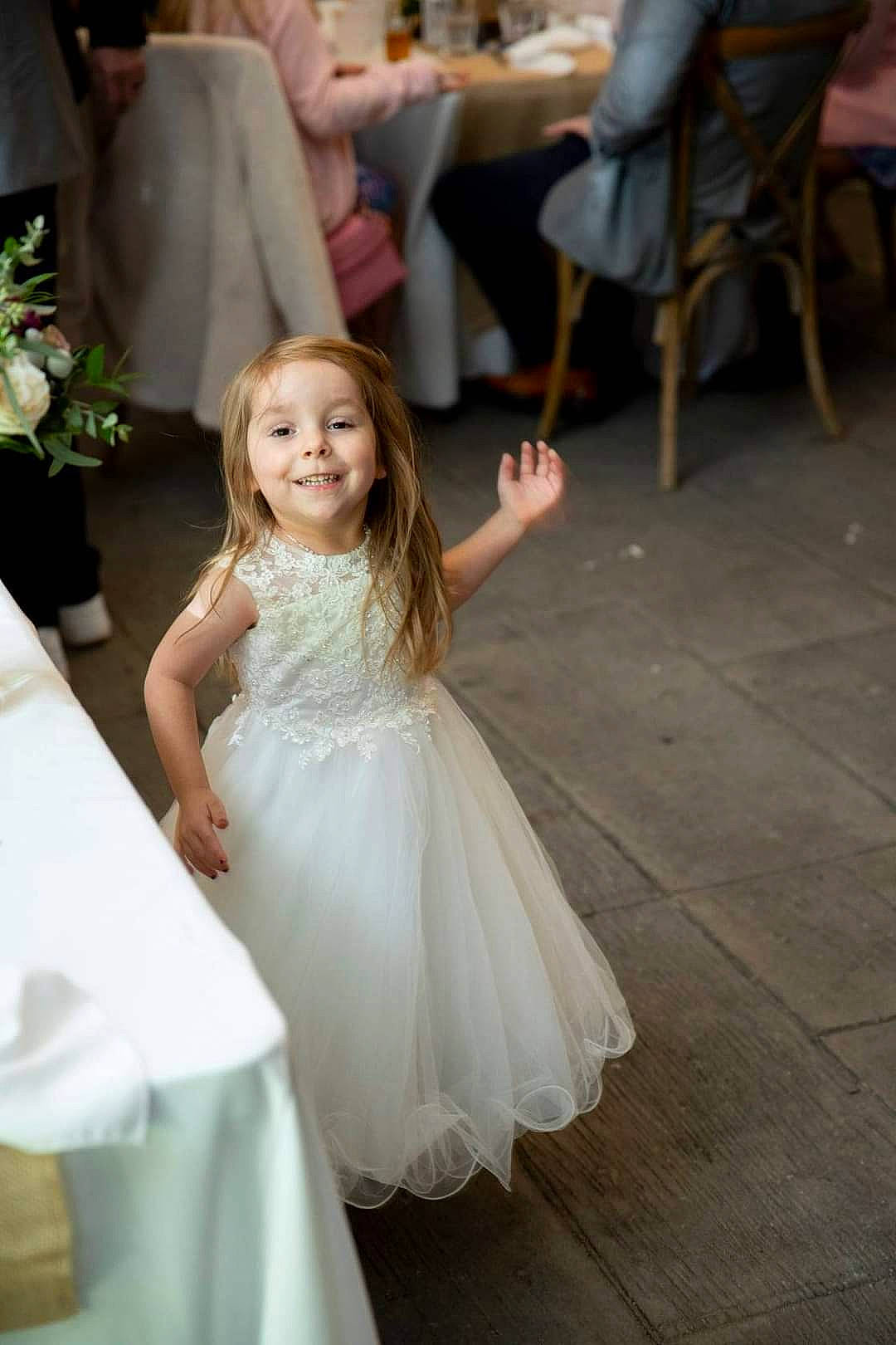 Hailie is registered to the contest to win money with this photo: bridal_accessory, bridal_clothing, bridal_party_dress, chair, dress, event, facial_expression, flooring, flower, formal_wear, fun, gesture, gown, happy, joy, marriage, person, smile, toddler, wedding_ceremony_supply