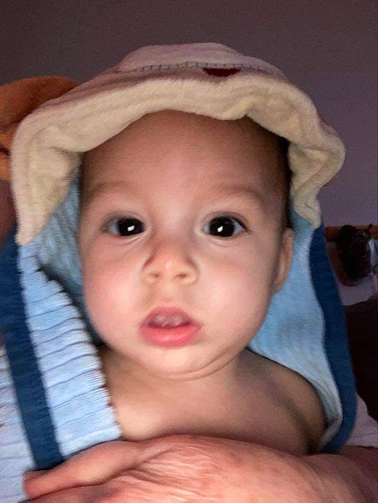 Xavier is registered to the contest to win money with this photo: baby, cap, cheek, child, eyebrow, eyelash, face, fedora, finger, forehead, hair, headwear, human_body, iris, lip, mouth, nose, person, skin, smile