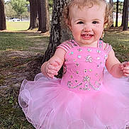 Ellerie is registered to the contest to win money with this photo: toddler, child, pink_dress, tutu, bow, smiling, outdoor, trees, grass, cute, happy, curly_hair, nature, portrait, baby, playful, sunlight, face, person, park
