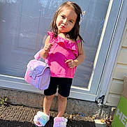 Kelahnie joined the competition — help win amazing prizes! child, girl, pink_top, black_shorts, handbag, fluffy_slippers, standing, outdoor, door, pavement, sunlight, playful, posing, hair_clip, smiling, cute, fashion, accessory, footwear, sidewalk