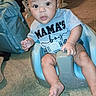 baby, baby_gear, backpack, bare_feet, blue_seat, carpet, child, clothing, flash_photography, happy, harness, home, indoor, infant, living_room, mamas_boy, open_mouth, portrait, sitting, wide_eyes