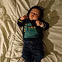 adorable, baby, bed, blanket, casual, child, clothing, cute, dinosaur, fist, hoodie, indoor, infant, jeans, lying_down, portrait, pose, shadow, socks, young_child