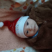 Armel a rejoint le concours — aidez-le/la à gagner de superbes lots ! baby, brown_clothing, child, colorful, cute, eyes, face, festive, headwear, holiday, indoors, infant, lying_down, polka_dots, portrait, santa_hat, soft_texture, towel, winter_clothing, young_child