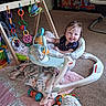 baby, baby_walker, blanket, carpet, child, colorful, cute, floor, furniture, happy, indoor, infant, person, plastic_toys, playful, smiling, soft_toys, toys, wooden_toy, young_child