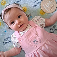 Audrianna is registered to the contest to win money with this photo: baby, child, infant, pink_dress, headband, smiling_sun, blanket, strawberry, cute, portrait, lying_down, happy, young_child, soft_lighting, indoor, close_up, adorable, toddler, clothing, face