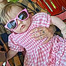 accessory, adult, baby, casual, child, closeup, cool, cute, fashion, funny, gingham_dress, greenery, outdoor, person, pink_sunglasses, portrait, red_chair, sitting, summer, tattooed_hand