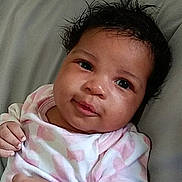 Winter joined the competition — help win amazing prizes! baby, infant, child, lying_down, pillow, onesie, pink, white, curly_hair, face, smile, looking_at_camera, young_child, indoors, cute, portrait, skin, hand, head, expression