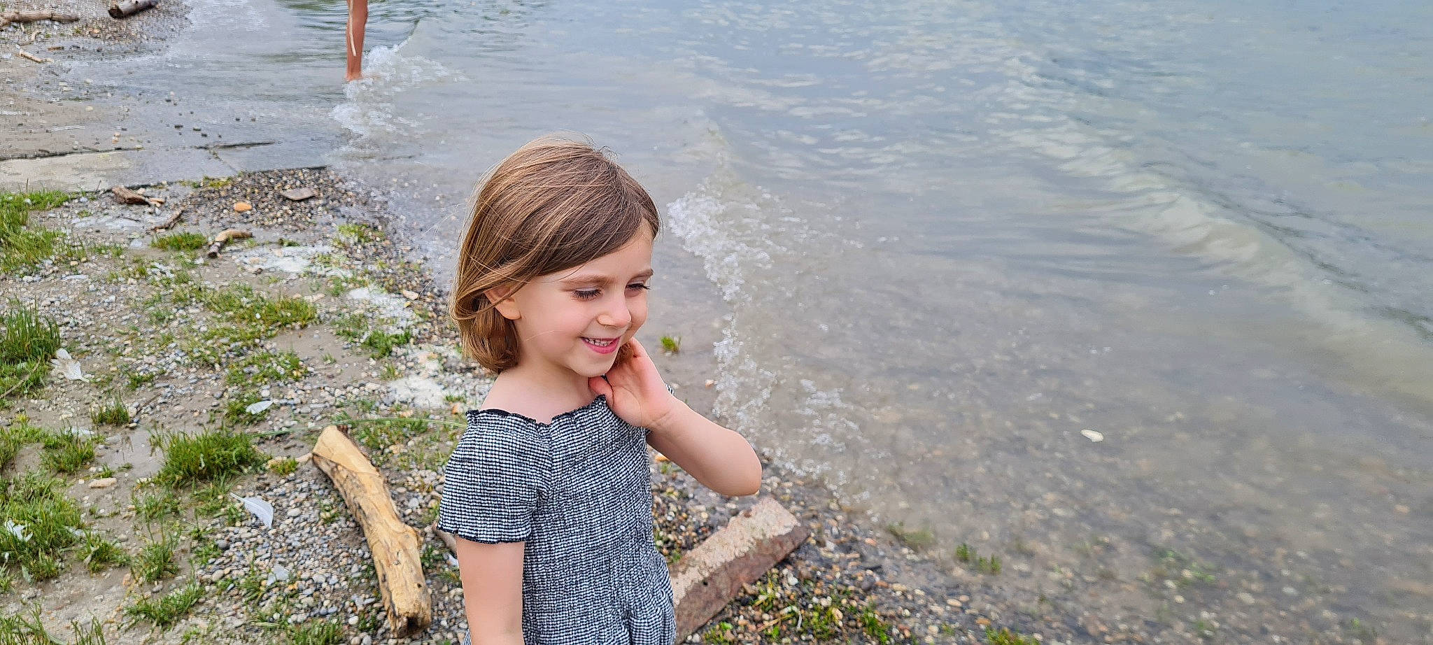 Abygaël participe au concours pour gagner de l'argent avec cette photo : bank, beach, child, face, fun, grass, hair, happy, joy, lake, landscape, leisure, nature, people_in_nature, person, smile, standing, summer, toddler, travel