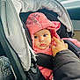 baby, child, car_seat, pink_jacket, unicorn_print, hood, hand, straps, car_interior, seatbelt, infant, person, winter_clothing, cute, portrait, safety, seat, young_child, warm_clothing, closeup