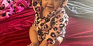 Kaitlyn is registered to the contest to win money with this photo: baby, child, smiling, hood, robe, leopard_print, blanket, bed, red, pink, soft, cute, indoors, happy, person, sitting, face, feet, hand, warm
