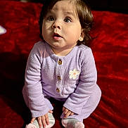 Kaitlyn joined the competition — help win amazing prizes! baby, child, infant, purple_clothing, knitwear, sitting, red_blanket, plush, cute, hands, feet, socks, portrait, indoors, expression, looking_up, face, hair, buttoned_sweater, earrings