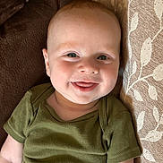 Jackson joined the competition — help win amazing prizes! baby, smile, face, couch, green_clothing, infant, happy, portrait, child, sitting, comfortable, indoors, closeup, cushion, fabric, skin, head, eyes, tongue, young