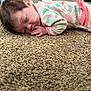 baby, sleeping, carpet, onesie, infant, child, floor, cozy, indoor, person, hand, face, hair, footwear, furniture, room, carpet_texture, peaceful, soft, resting