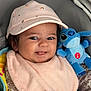 baby, child, pink_cap, bib, plush_toy, stitch, blue_toy, smiling, tongue_out, baby_seat, clothing, cute, infant, face, closeup, indoor, soft_toy, happy, person, adorable