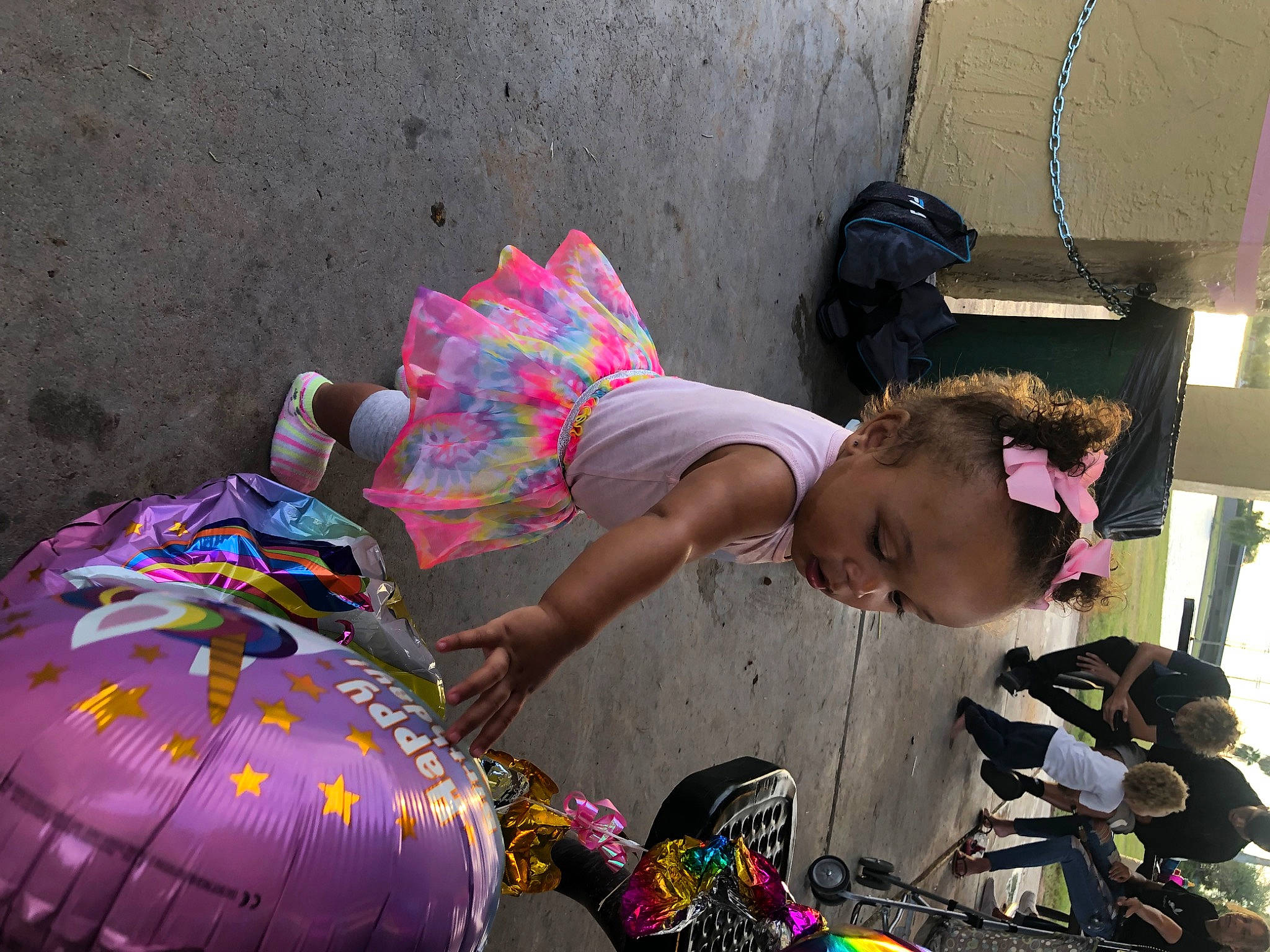 Isis Blue is registered to the contest to win money with this photo: child, event, eyewear, fashion_accessory, fun, human_leg, leisure, magenta, pattern, person, personal_protective_equipment, pink, play, sandal, shorts, sitting, street, toddler, vacation