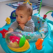 Naël participe au concours pour gagner de l'argent avec cette photo : baby, child, toy, activity_center, play_area, indoor, curious, colorful, plastic_toy, infant, seat, floor, crawling, hand, face, clothing, playtime, early_childhood, development, fun