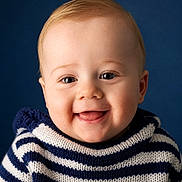 Noé a rejoint le concours — aidez-le/la à gagner de superbes lots ! baby, smiling, portrait, child, blue_background, striped_sweater, cute, happy, face, infant, young_child, sitting, studio_photo, closeup, headshot, person, indoors, light_skin, short_hair, casual_clothing
