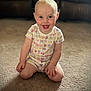 toddler, child, smile, happy, carpet, sitting, onesie, colorful_clothing, indoor, living_room, face, baby, cute, short_hair, bright_eyes, fun, playful, person, couch, background