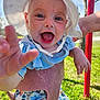baby, child, smiling, hat, sunhat, blue_clothing, floral_pants, outdoor, green_grass, hand, person, happy, closeup, playground, sunlight, nature, cute, infant, reaching_hand, daytime