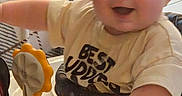 Dayton is registered to the contest to win money with this photo: baby, child, indoor, smiling, baby_walker, toy, shirt, face, hand, furniture, couch, floor, person, happy, young_child, home, clothing, infant, play, seat