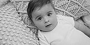 Jesse joined the competition — help win amazing prizes! baby, infant, child, portrait, face, eyes, expression, onesie, white_clothing, pillow, texture, knitted, soft, black_and_white, laying_down, indoor, close_up, cute, young, innocent