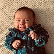 Mia a rejoint le concours — aidez-le/la à gagner de superbes lots ! baby, smiling, happy, infant, blue_clothing, floral_pattern, blanket, texture, cheeks, fist, cute, lying_down, portrait, child, young, face, skin, head, small_hands, cozy
