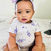 Dream joined the competition — help win amazing prizes! baby, child, infant, sitting, bed, headband, purple, onesie, floral, cute, hands, face, portrait, indoors, skin, expression, curious, phone, soft, cozy