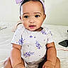 baby, child, infant, sitting, bed, headband, purple, onesie, floral, cute, hands, face, portrait, indoors, skin, expression, curious, phone, soft, cozy