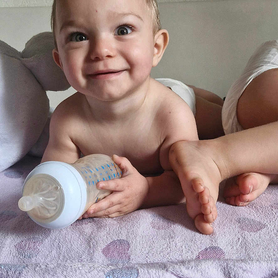 Luca participe au concours pour gagner de l'argent avec cette photo : baby, bed, beverage, bodypart, couch, cup, cushion, disposablecup, face, finger, furniture, hand, happy, head, homedecor, milk, person, photography, portrait, smile