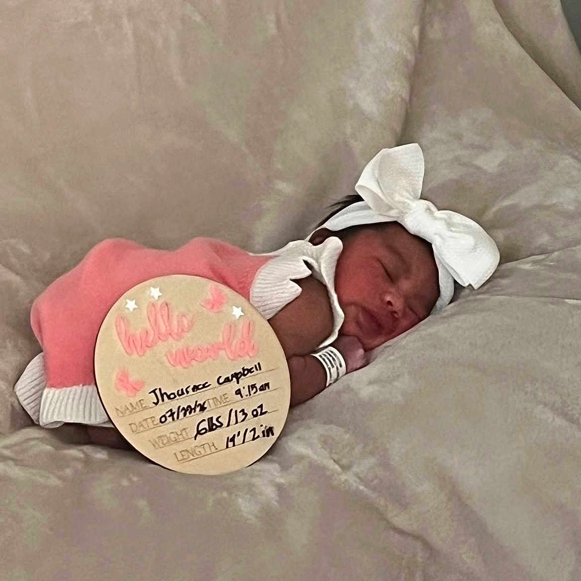Jhournee is registered to the contest to win money with this photo: newborn, baby, sleeping, pink_outfit, white_bow, headband, blanket, soft_texture, sign, birth_details, infant, peaceful, cute, portrait, child, resting, indoors, closeup, person, sleep