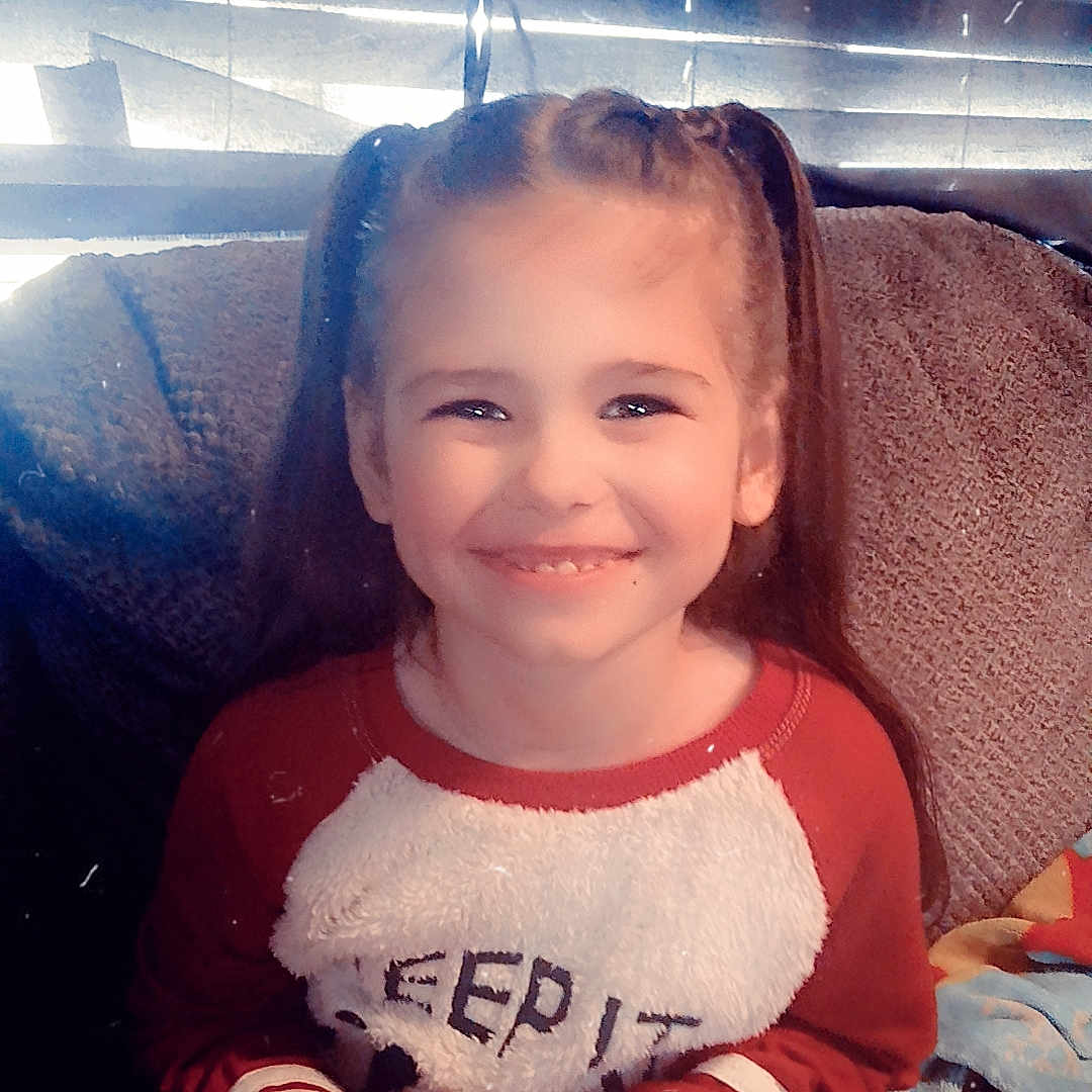 Elena is registered to the contest to win money with this photo: bodypart, child, clothing, couch, cushion, face, female, finger, furniture, girl, hand, happy, head, homedecor, pants, person, photography, portrait, sitting, t_shirt