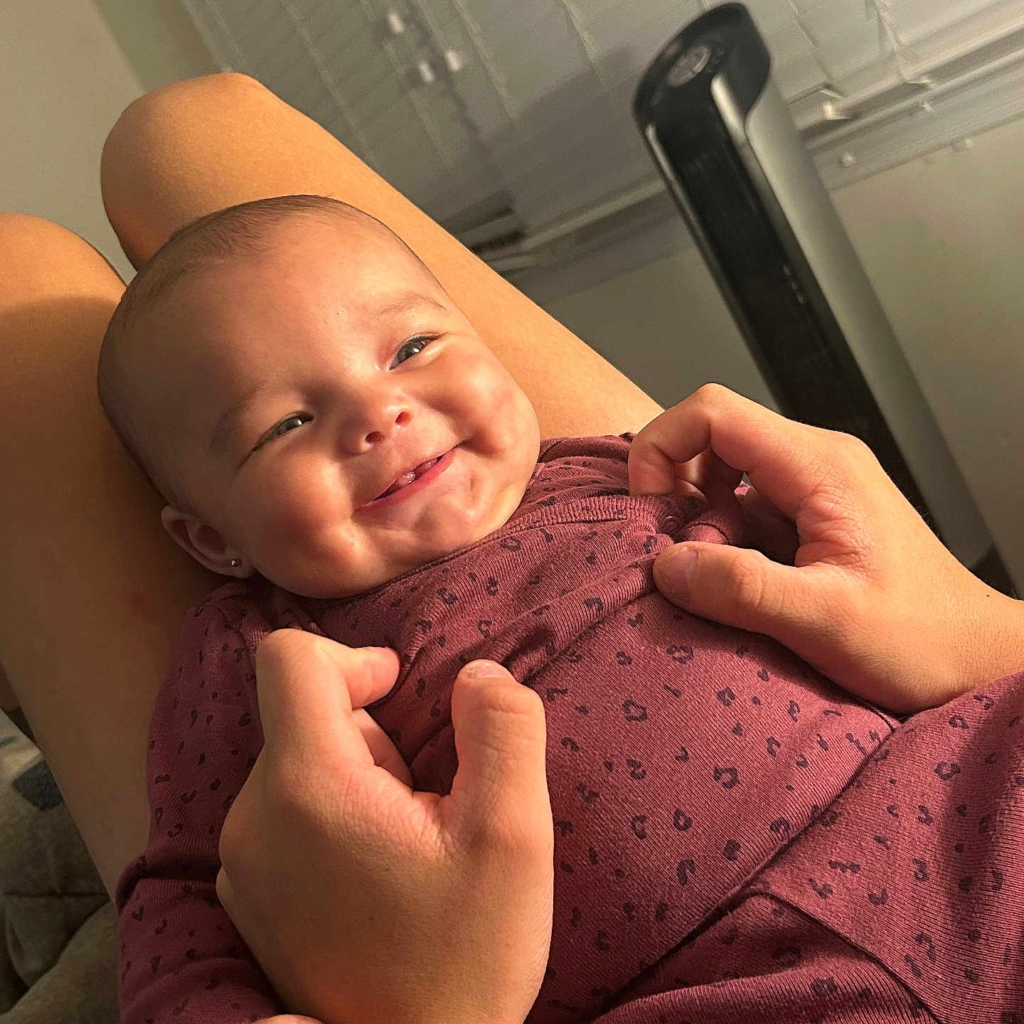 Elaina is registered to the contest to win money with this photo: baby, child, comfort, cozy, cute, face, fan, hands, happy, holding, human, indoor, infant, joy, maroon_clothing, person, skin, smiling, toddler, window_blinds