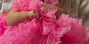 Kailani is registered to the contest to win money with this photo: baby, child, smiling, pink, tutu, headband, blanket, infant, cute, happy, patterned, clothing, laying, portrait, face, hands, legs, indoors, soft_lighting, colorful