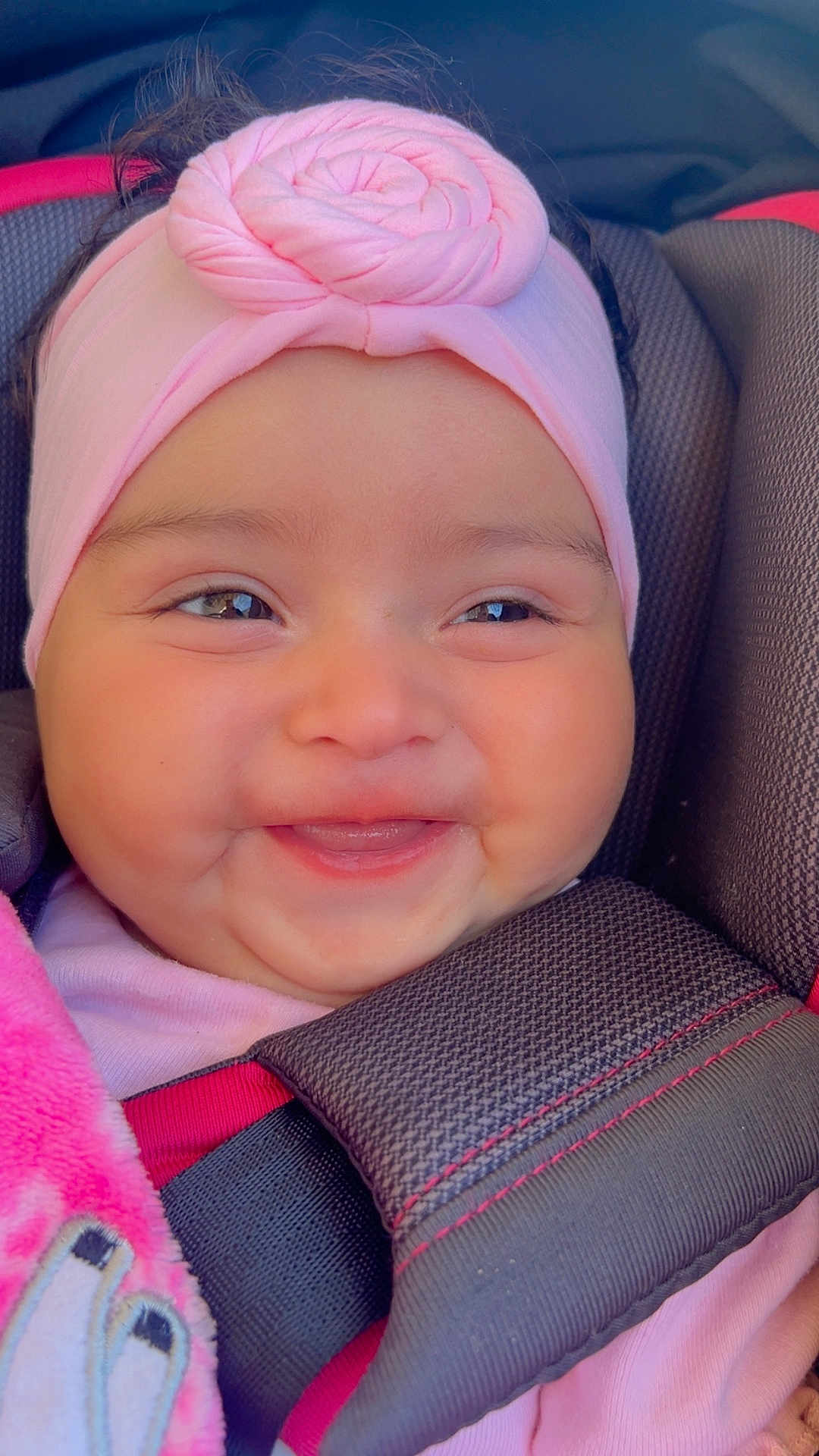 Kailani joined the competition — help win amazing prizes! baby, smiling, headband, pink, car_seat, blanket, child, face, cute, happy, infant, clothing, closeup, person, young_child, seatbelt, cozy, portrait, adorable, seat