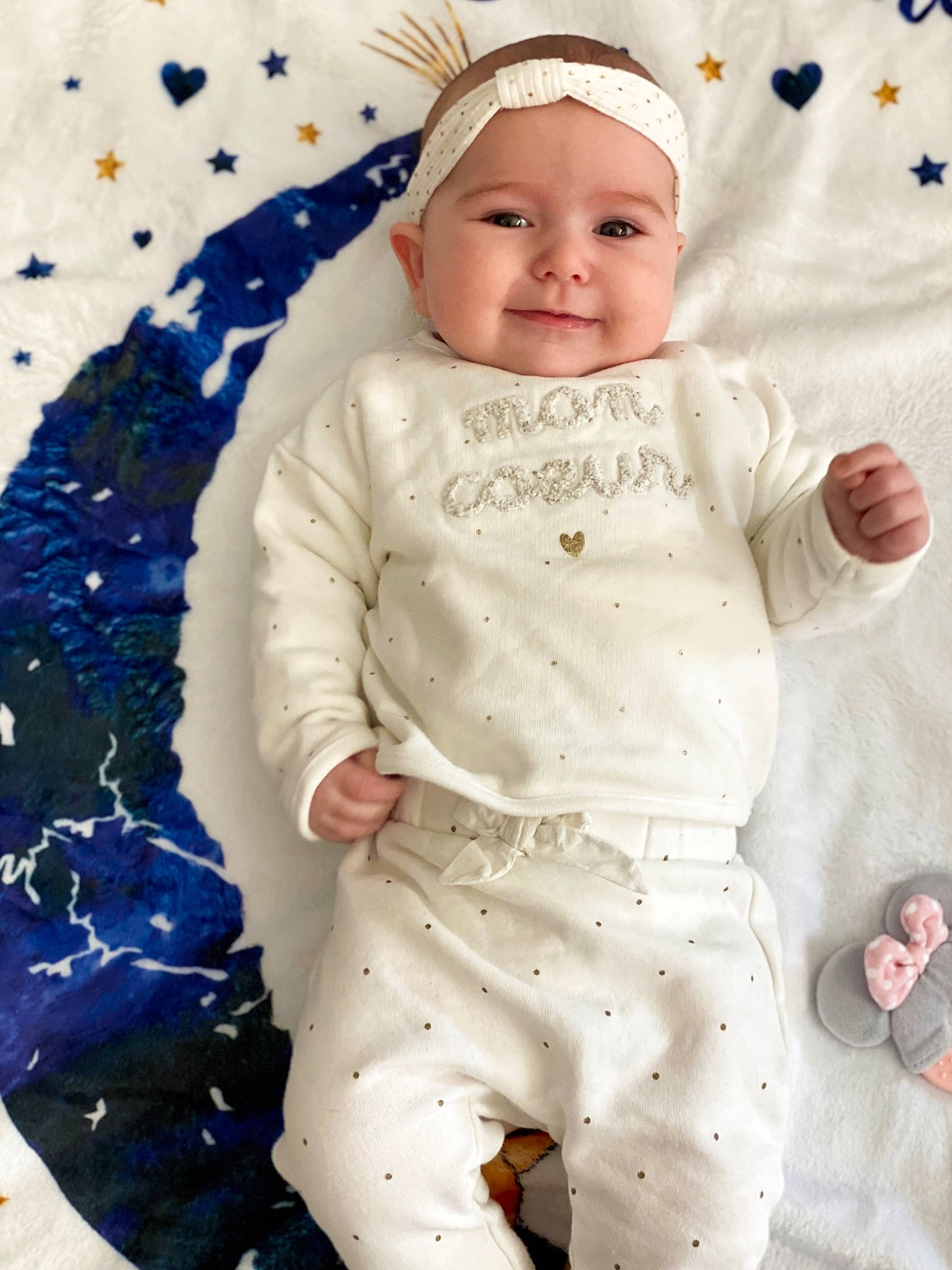 Lyana a rejoint le concours — aidez-le/la à gagner de superbes lots ! baby, baby_products, baby_toddler_clothing, cap, cheek, child, face, gesture, happy, headwear, joy, linens, pattern, person, portrait_photography, room, sitting, sleeve, smile, textile