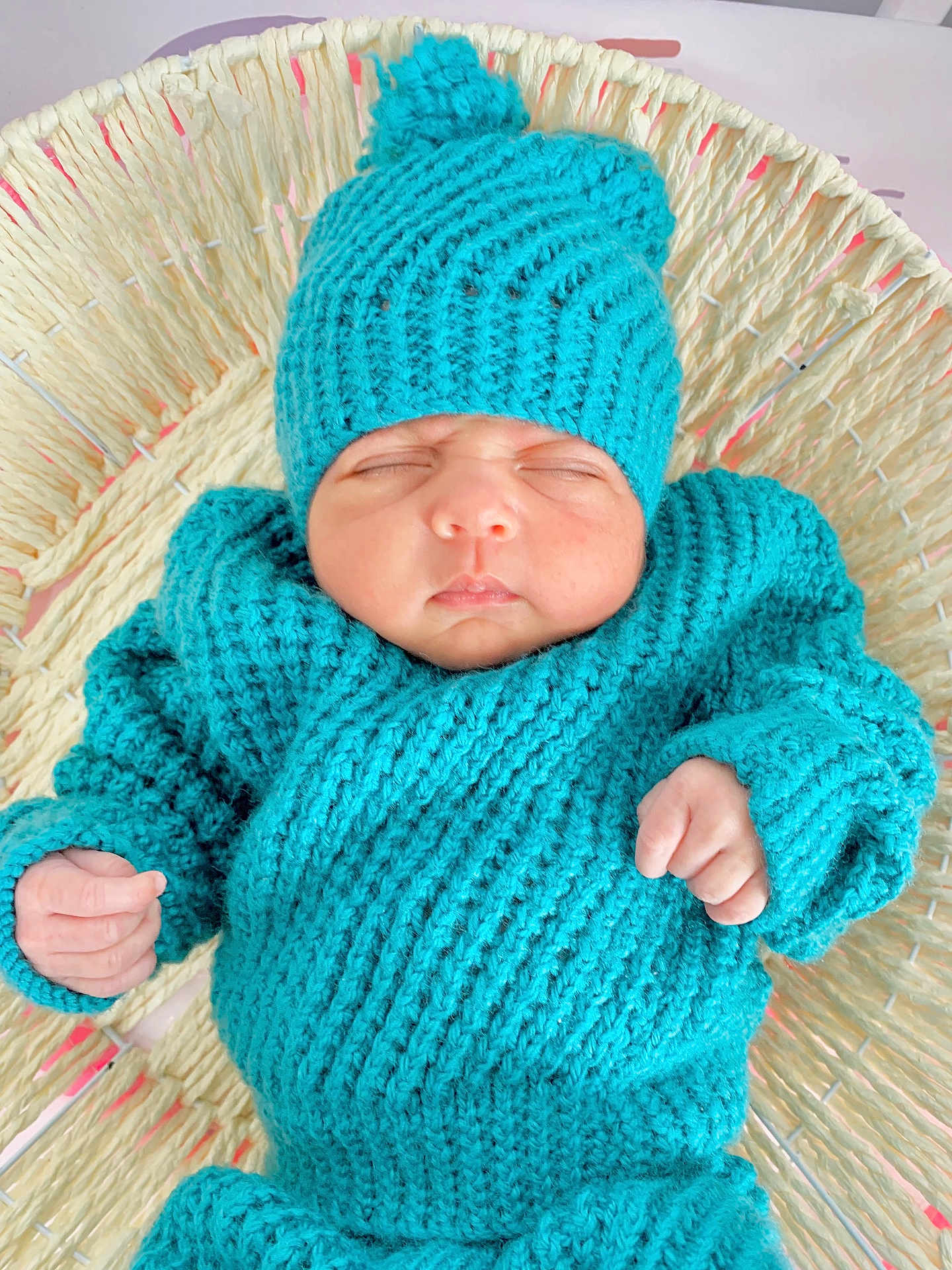 Samavia is registered to the contest to win money with this photo: baby, basket, clothing, cozy, cute, face, hand, headwear, indoors, infant, knitted_hat, knitted_sweater, newborn, peaceful, portrait, resting, sleeping, soft_texture, turquoise, woven_basket