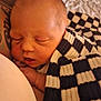 Brodie is registered to the contest to win money with this photo: newborn, baby, sleeping, blanket, checkered, tattoo, skin, closeup, cozy, infant, peaceful, resting, wrapped, comfort, soft, portrait, human, child, warm, cuddle