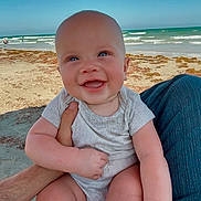Owen is registered to the contest to win money with this photo: baby, beach, blue_sky, casual_clothing, child, hand, happy, holding, infant, legs, nature, ocean, outdoor, person, sand, seagull, skin, smiling, summer, waves