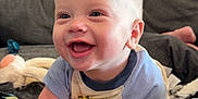 Owen joined the competition — help win amazing prizes! baby, blanket, blue_shirt, child, close_up, clothing, couch, expression, face, happy, holding, home, indoor, infant, person, playful, skin, smiling, soft_toys, toys