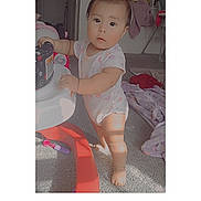 Ashley Isaguirre is registered to the contest to win money with this photo: baby, child, toddler, standing, portrait, face, smiling, indoors, playroom, toy, furniture, carpet, clothing, onesie, barefoot, nursery, house, heart_sticker, text_overlay, photograph